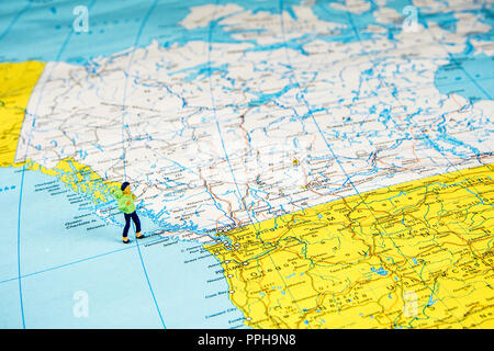 Nahaufnahme der Miniatur Figur der jungen Reisenden stehen auf große Karte Kanada Stockfoto