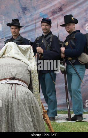 Union Soldaten Teil einer Amerikanischen Bürgerkrieg reenactment für einen Fotografen in Kostümen gekleidet und mit einer alten Kamera aus der Zeit darstellen. Stockfoto