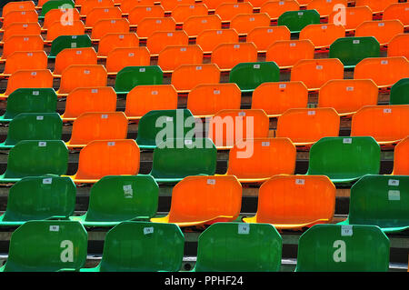 Seite Blick auf Grün und Orange Kunststoff Sitze mit Zahlen auf einer Tribüne an ein Open Air Theater Stockfoto