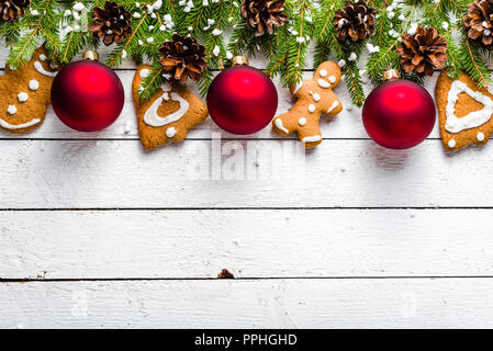 Weihnachtskarte mit Lebkuchen cookies und Tannenbaum auf weissem Holztisch Stockfoto