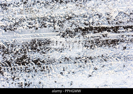 Die Beschaffenheit der Straße im Winter, Asphalt bedeckt Schnee und Reifenspuren Stockfoto