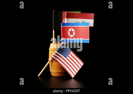 Eine nationale Flaggen von Nordkorea, Irak und Afghanistan im kleinen Holzfass. Schwarzer Hintergrund Stockfoto