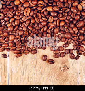 Geröstete Kaffeebohnen auf Holztisch, Hintergrund Stockfoto