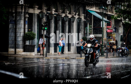 Athen Griechenland/Juni 16, 2018: Mann reiten Motorrad im Zentrum Athens im Regen Sturm Stockfoto