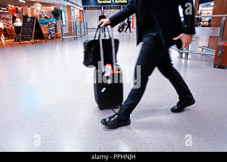 Ein Passagier zu Fuß durch den Flughafen nach der Ankunft am internationalen Flughafen Manchester T1 Ankunftshalle Stockfoto