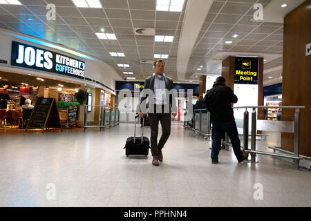 Ein Passagier zu Fuß durch den Flughafen nach der Ankunft am internationalen Flughafen Manchester T1 Ankunftshalle Stockfoto