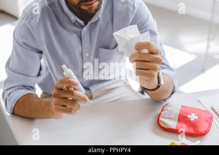 Zugeschnittenes Bild von kranken Manager holding Nasenspray und Gewebe im Büro Stockfoto