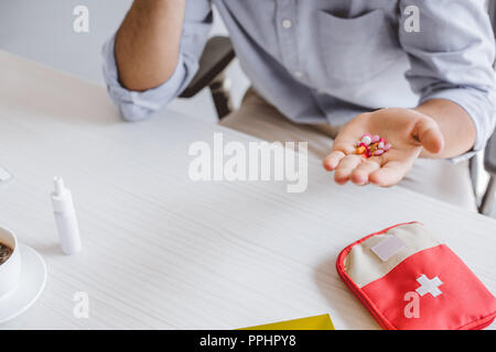 Zugeschnittenes Bild von kranken Manager holding Pillen im Büro Stockfoto