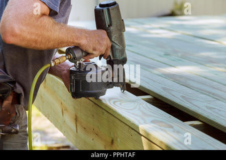 Installation Holz an Deck, Terrasse bau Mann mit Pneumatic nailer Druckluftpistole Stockfoto