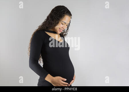 Close-up Studio shoot der schwangeren Frau, ihren Bauch berühren. Auf weissem Hintergrund Stockfoto