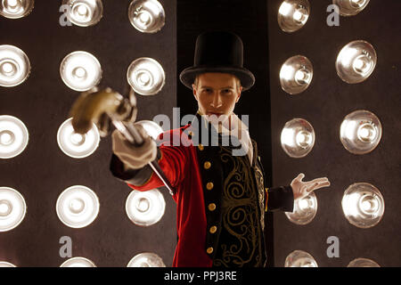 Showman. Junger männlicher Entertainer, Moderator und Schauspieler auf der Bühne. Der Kerl im roten Leibchen und dem Zylinder. Stockfoto
