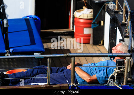 Candid reifer Mann der schläft im Heck des Schiffes. Auf dem Rücken in den Sommer Sonnenschein Stockfoto