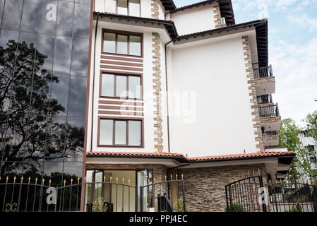 Modernes Gebäude an der Außenseite. Fassade ein modernes Apartmentgebäude. Ferienhäuser Complex Hotel Gebäude, mit Stein Fliesen Fassade. Stockfoto