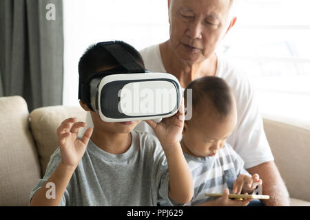 Asian Boy mit VR-Brille mit großeltern Technik Foto Stockfoto