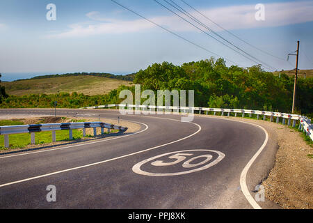 Eine gefährliche Wendung in der Landschaft. Die Höchstgeschwindigkeit beträgt 50 km/h. Für Rechtsverkehr. Stockfoto