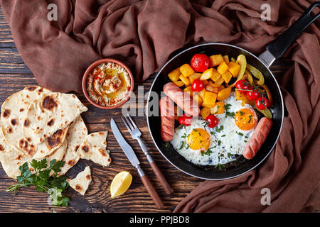 Ansicht von oben auf die gesunde Mahlzeit: Spiegeleier, Ahorn verglaste Kürbis Chunks, Würstchen mit Auberginen baba ganoush gewürzt Mit cayenne pfeffer, Fladenbrot, l Stockfoto