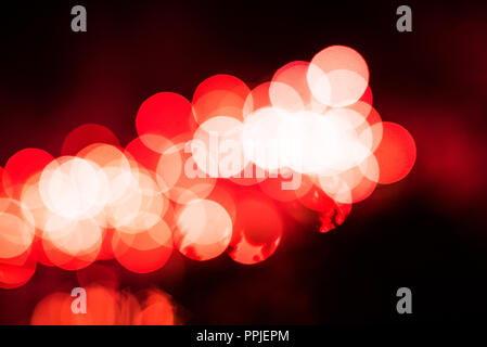 Abstrakte defokussierten Rot glitzernden Leuchten Lampen Beleuchtung bokeh auf verschwommenes grün Hintergrund in bunten warmen Ton auf Weihnachten und das Neue Jahr conceptspark Stockfoto