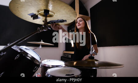 Junge rothaarige Mädchen arbeiten hinter einer in einem dunklen Studio drum Set Stockfoto
