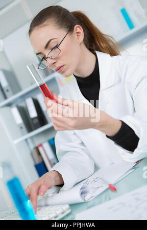 Junge Wissenschaftlerin dabei einige Eingänge auf dem Computer Stockfoto