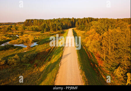 Ländliche Schmutz der Straße Blick von oben. Transport Hintergrund. Schöne Antenne Landschaft mit Straße in bunten Herbst Natur. Luftaufnahme auf Land Stockfoto