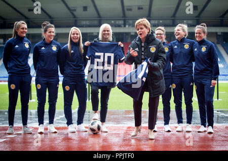 Erster Minister Nicola Sturgeon (Mitte rechts) Finanzierung kündigt für Nationale des Schottischen Frauen Fußball-Team mit Nationaltrainer Shelley Kerr (Mitte links), und einige der ersten Mannschaft Spieler, am Hampden Park, Glasgow. Stockfoto