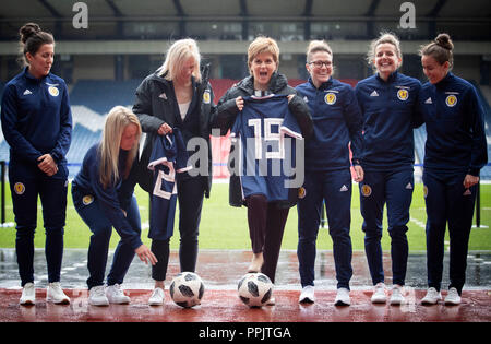 Erster Minister Nicola Sturgeon (Mitte) Finanzierung kündigt für Nationale des Schottischen Frauen Fußball-Team mit Nationaltrainer Shelley Kerr (3. links), und einige der ersten Mannschaft Spieler, am Hampden Park, Glasgow. Stockfoto