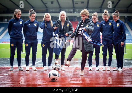 Erster Minister Nicola Sturgeon (Mitte rechts) Finanzierung kündigt für Nationale des Schottischen Frauen Fußball-Team mit Nationaltrainer Shelley Kerr (Mitte links), und einige der ersten Mannschaft Spieler, am Hampden Park, Glasgow. Stockfoto