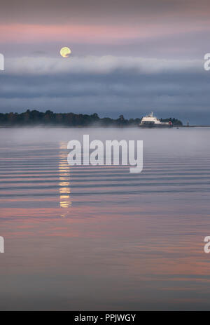 Morgen Vollmond. Untergang auf der Fraser River in Richmond, British Columbia, Kanada. Stockfoto