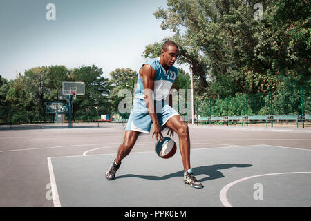 Bild von jungen verwirrt afrikanischen Basketball Spieler üben im Freien. Passen afro Mann in der Bewegung und Bewegung. athletischen und Sport Lifestyle Konzept Stockfoto