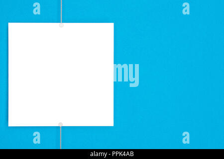 Papier Karte (Photo Frame) auf Metall hängende Seil mit Magneten auf blauem Hintergrund Stockfoto