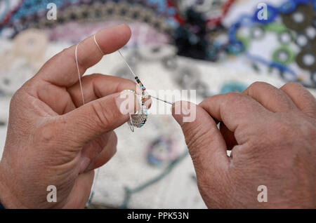 Nahaufnahme der Frau Hände stricken und bunten Hintergrund. Stockfoto