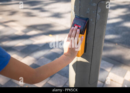 Nahaufnahme der Hand eines Kindes auf dem kapazitiven Taster einer Fußgängerampel Stockfoto