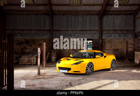 Leuchtend gelben Lotus Evora in einem Bauernhof in den Cotswolds, England, Großbritannien Stockfoto