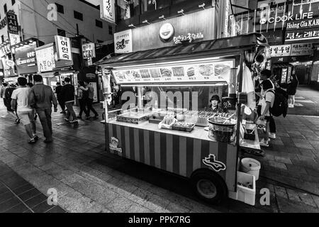 Suwon, Südkorea - 14. Juni 2017: Anbieter Frau warten auf Käufer in ihrer fast food Kiosk an der Hauptstraße in Suwon. Stockfoto