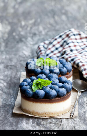 Zwei mini Schokolade Käsekuchen mit frischen Heidelbeeren auf hölzernen Tisch Stockfoto