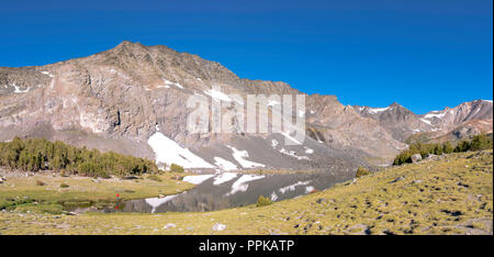 Ein angler nimmt seine Chancen; Sonnenaufgang über Alger Seen mit Asphalt Peak im Hintergrund; Ansel Adams Wilderness, Inyo National Forest, Sierra Beim Stockfoto