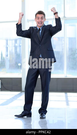 Jubilant Geschäftsmann in der geräumigen Lobby des Amtes. Stockfoto
