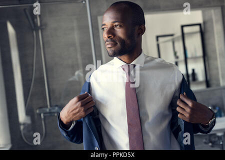 Hübscher junger Geschäftsmann Dressing up für Arbeit Stockfoto