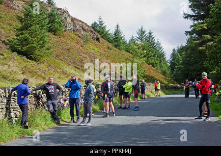 Radfahrer und Zuschauer warten geduldig in der Nähe der Oberseite der Whinlatter Pass, Cumbria, vor Beginn der Phase 5 Mannschaftszeitfahren, Tour durch Großbritannien 2018 Stockfoto