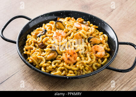 Traditionelle spanische fideua. Nudel Paella auf hölzernen Tisch. Nahaufnahme Stockfoto