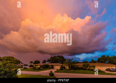 Riesige rötliche sumnmer Sturmwolken über Häuser im Südwesten Florida United States Stockfoto