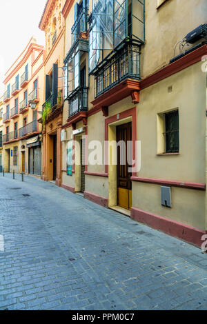 Die schmalen Gebäude der historischen Stadt mit wunderschön gestalteten bunten Häusern und engen Gassen der Altstadt. Sevilla, Spanien Stockfoto