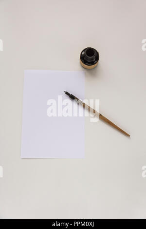 Eine alte nib-Stift, eine Flasche schwarze Tinte, ein Blatt Papier mit Platz für Text, Einladung schreiben. Alte nib-Stifte. Stockfoto