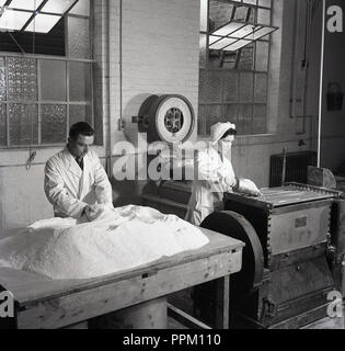 1950, historische, männliche und weibliche Arbeitnehmer in Weiß-Mantel an Arthur H. Co&Co die Vorbereitung der Rohstoffe in die Hersteller der Medikamente verwendet ot Tabletten, Brighton, England, UK. Stockfoto