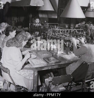 1950, historische, Frauen in einem Werk der immer bereit ist, seiner Firma, einem der führenden britischen Hersteller von Batterien, Taschenlampen, Fahrradbeleuchtung und Radios, die in dieser Zeit arbeiten. Mit einer Reihe von Fabriken um Großbritannien und Tausende von Arbeitern, die stets bereit ist, dominiert die Zink-Kohle-Batterie Markt sowohl in Großbritannien als auch in Südafrika. Stockfoto