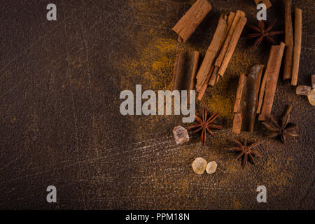 Zimtstangen, Sternanis Sprossen und karamellisierten Zucker auf einem dunklen Hintergrund. Blick von oben. Close-up. Stockfoto