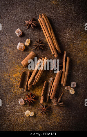 Zimtstangen, Sternanis Sprossen und karamellisierten Zucker auf einem dunklen Hintergrund. Blick von oben. Close-up. Stockfoto