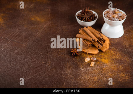 Zimtstangen, Sternanis Sprossen und karamellisierten Zucker auf einem dunklen Hintergrund. Blick von oben. Close-up. Stockfoto