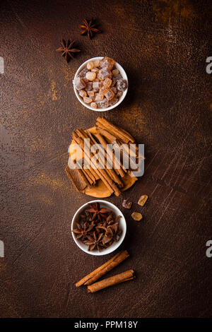 Zimtstangen, Sternanis Sprossen und karamellisierten Zucker auf einem dunklen Hintergrund. Blick von oben. Close-up. Stockfoto