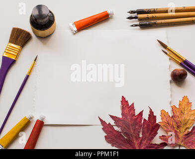 Eine alte Schreibfedern pen, eine Flasche schwarze Tinte, ein Blatt Papier mit Platz für Text, Einladung schreiben, Alte nib Stiften, Pinseln, trockene Blätter, Röhren von Lack, Stockfoto